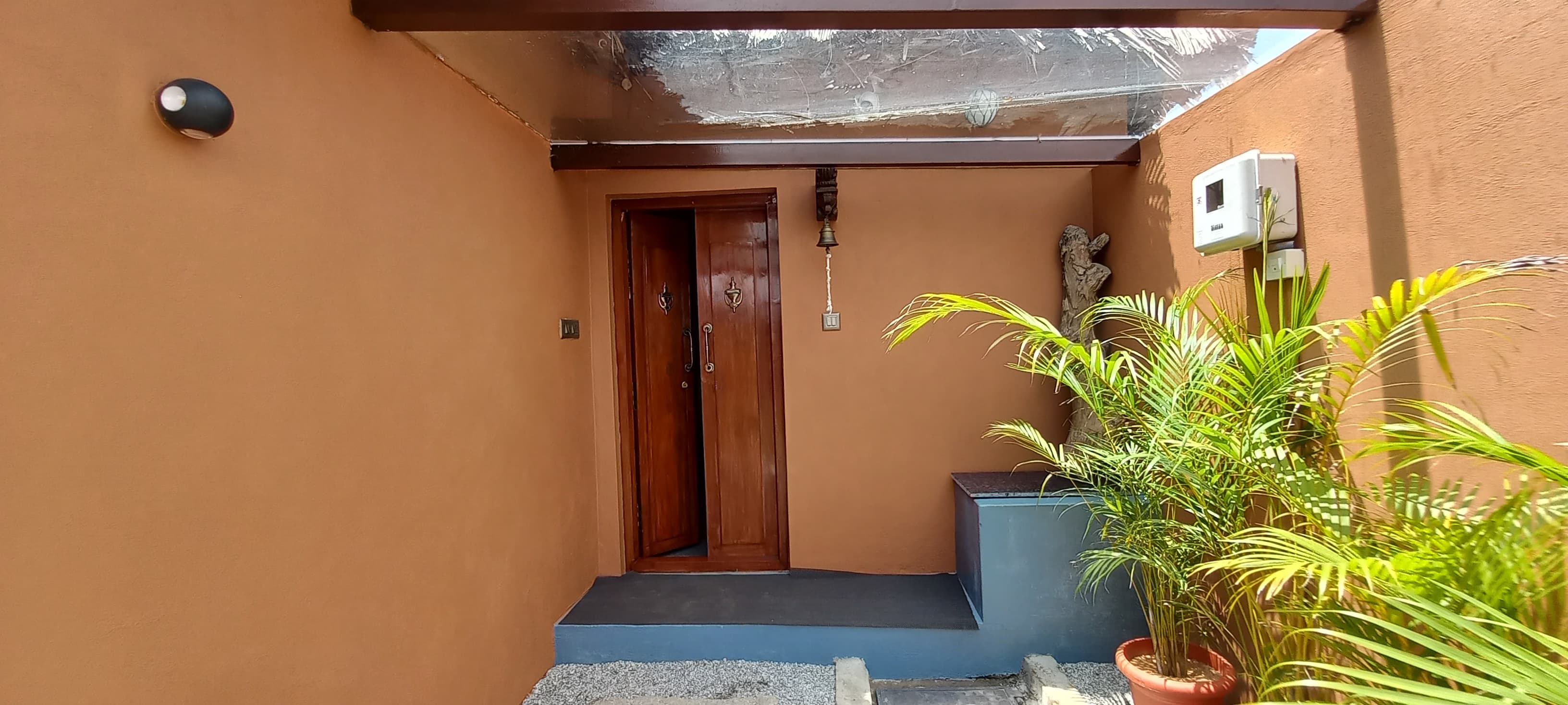 Elephant Hill Villa entrance with earthy walls and palm plants